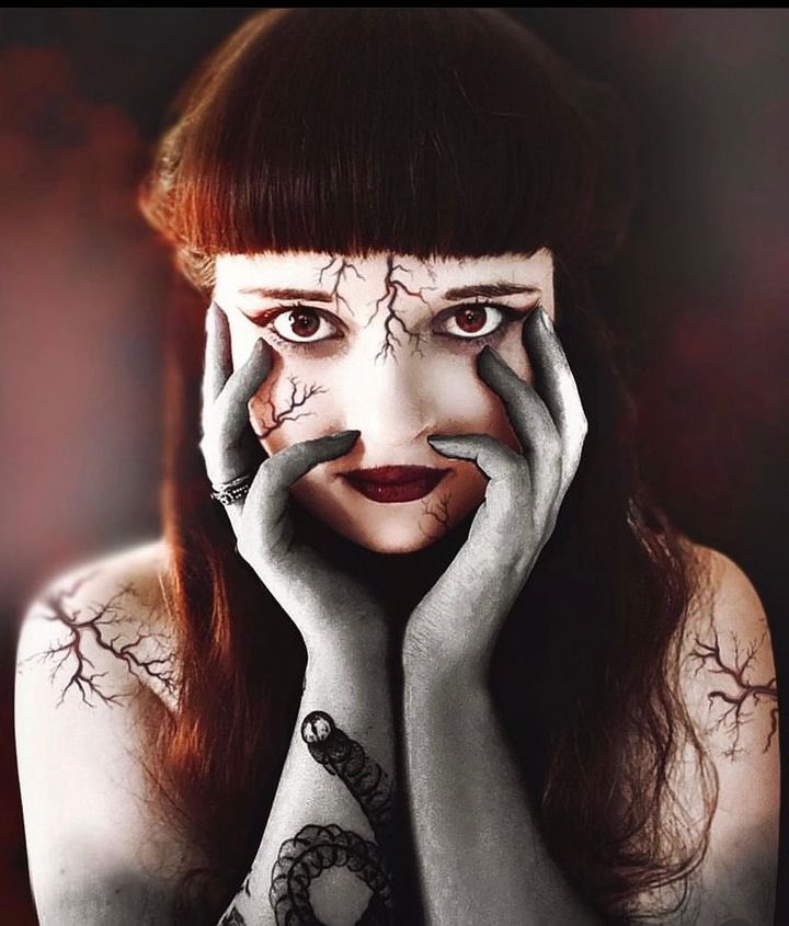 une jeune fille avec des veines noires et des mains sur le visage